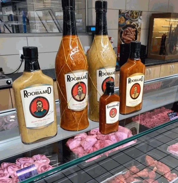 Rooibaard Original Peri Peri Sauce bottles displayed on a counter.