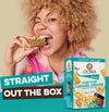 Ouma Rusks Yum Yum Caramel Dreams packaging with a woman enjoying a rusk straight from the box.