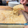 Glass dish of baked crumbly dessert with guava halves.