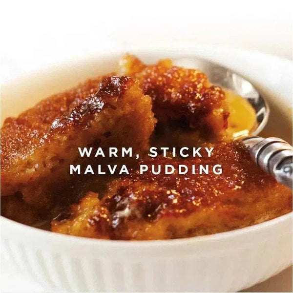 Warm Malva Pudding in a bowl with spoon, showcasing golden caramelized top.