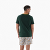 Man wearing 2XL Springbok Pajama Set with green short-sleeve top and white elastic waist shorts with Springbok logo pattern, back view