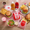 Wimpy Tomato Sauce 500ml bottle with various fast food items, including burgers, fries, and drinks, showcasing its versatility as a condiment.