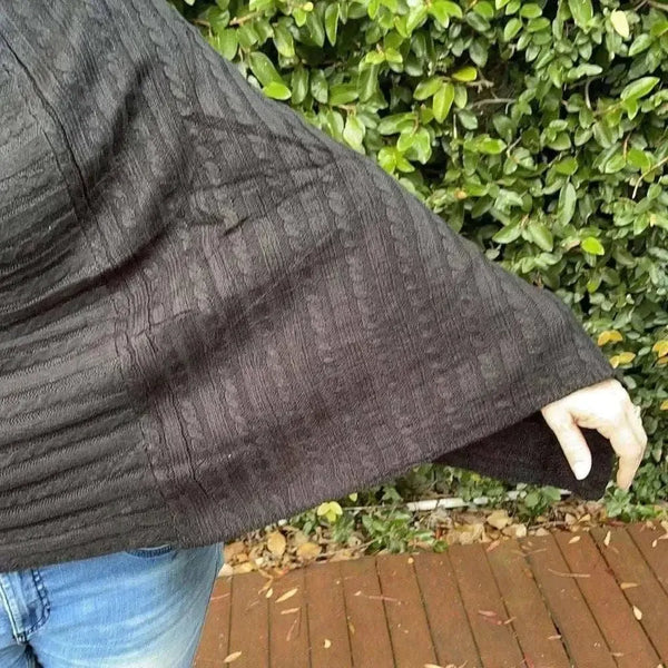 Black knitted cotton winter poncho with round neck