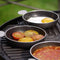 CADAC Tapas set of 4 non-stick pans on grill with tomatoes, eggs, and beans cooking outdoors.